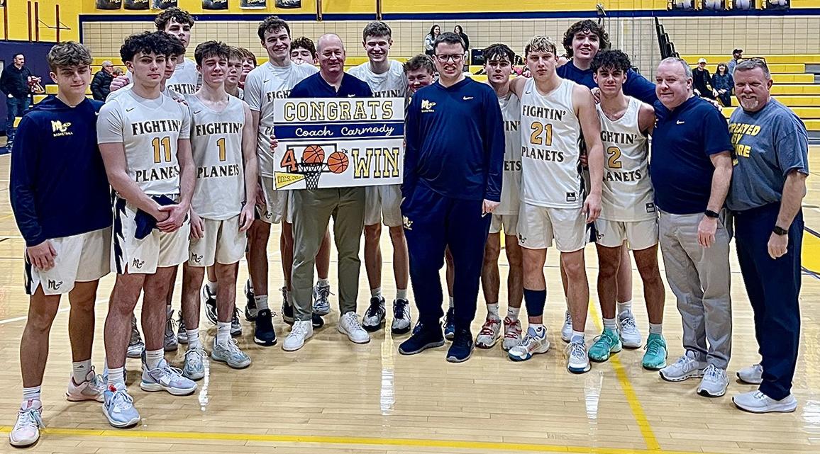 Mars Area High School Boys Varsity Basketball head coach Rob Carmody celebrates with the team after earning his 400th career win.